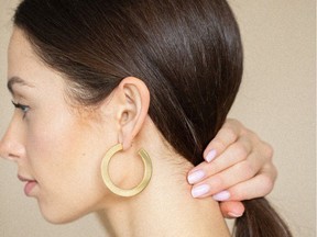 Up your ear-candy game this season with a pair of gold hoops. A model wears flat hoop earrings from the Vancouver-based brand Melanie Auld.