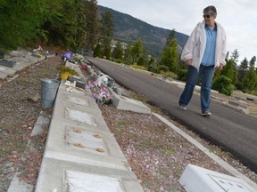 Police have recovered most of the 53 bronze markers stolen from the Westbank cemetery in West Kelowna. Patricia Caley is shown walking alongside the defaced gravesites in a file photo from Sept. 22.