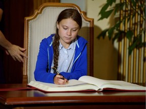 Climate change teen activist Greta Thunberg signs a book as she receives the key to the city from Montreal Mayor Valerie Plante after a climate strike march in Montreal last week.