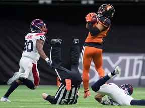 B.C. Lions' Lemar Durant (1) makes a reception behind Montreal Alouettes' Boseko Lokombo (20) as field judge Brian Chrupalo falls after colliding with Montreal's Jarnor Jones.
