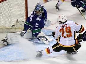 Vancouver Canucks' goalie Michael DiPietro tries to stop a shot by Calgary Flames' Dillion Dube during first period pre-season NHL hockey action in Victoria, Monday, Sept. 16, 2019.