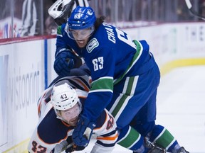 Vancouver Canucks defenceman Jalen Chatfield puts Edmonton Oilers right wing Josh Currie (43) into the boards during first period NHL preseason action in Vancouver, Tuesday, September, 17, 2019.