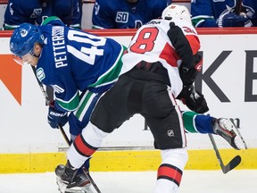 Vancouver Canucks' Elias Pettersson (40) is checked by Ottawa Senators' Rudolfs Balcers (38) during second period NHL pre-season hockey action in Abbotsford, B.C., on Monday, Sept. 23, 2019.