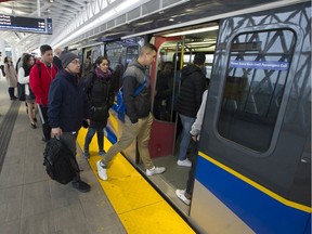 Passengers board a SkyTrain at the Broadway-Commercial station in Vancouver.