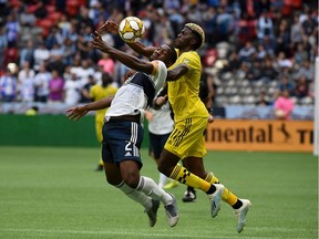 Doneil Henry of the Vancouver Whitecaps, left, heads the ball against Columbus Crew forward Gyasi Zardes during Saturday's MLS match at B.C. Place Stadium in Vancouver. The teams played to a 1-1 draw.