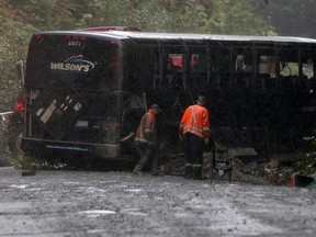 Search and rescue crews and RCMP help a tow-truck crew to remove a bus from the ditch of a logging road near Bamfield, B.C., on Saturday, September 14, 2019. Two University of Victoria students died and more than a dozen other people were injured after a bus on its way to a marine research centre rolled over on a narrow gravel road on Vancouver Island on Friday. The incident happened between the communities of Port Alberni and Bamfield, said the Joint Rescue Co-ordination Centre in Victoria.