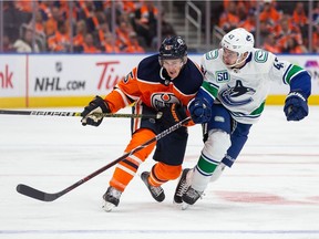 Josh Archibald of the Edmonton Oilers skates against Quinn Hughes of the Vancouver Canucks during the second period at Rogers Place on October 2, 2019, in Edmonton, Canada.