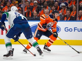 Connor McDavid of the Edmonton Oilers skates the puck past Tyler Myers of the Vancouver Canucks during the second period at Rogers Place.