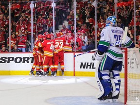 Elias Lindholm #28 of the Calgary Flames celebrates with his teammates after scoring against the Vancouver Canucks in Calgary Oct. 5.