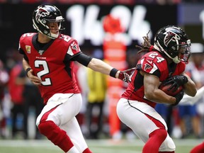 Matt Ryan #2 of the Atlanta Falcons hands off to Devonta Freeman #24 in the first half of an NFL game against the Los Angeles Rams at Mercedes-Benz Stadium on October 20, 2019 in Atlanta, Georgia.