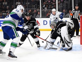 Jonathan Quick #32 of the Los Angeles Kings makes a save on a shot from Bo Horvat #53 of the Vancouver Canucks as Alec Martinez #27 attempt to clear the rebound during the first period at Staples Center on October 30, 2019 in Los Angeles, California.