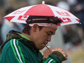 A person smokes marijuana during the annual 4/20 rally on Parliament Hill in Ottawa, Ontario, on April 20, 2019.