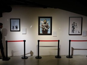 A security guard stands by replicas of British street artist Banksy's artworks displayed as part of the exhibition "The world of Banksy, the immersive experience" on October 15, 2019 at the Espace Lafayette-Drouot in Paris.
