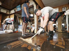 Canada's national rugby union team player Peter Nelson and other teammates help remove mud inside a house at a flooded area, caused by Typhoon Hagibis in Kamaishi, Iwate prefecture, Japan October 13, 2019.