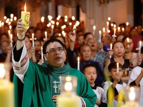 Catholic priest Anthony Dang Huu Nam holds a candle during a mass prayer for 39 people found dead in the back of a truck near London, UK at My Khanh parish in Nghe An province, Vietnam October 26, 2019.