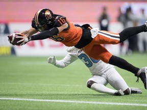 Lions' Bryan Burnham (16) dives across the goal line to score a touchdown in front of Toronto Argonauts' Trumaine Washington.