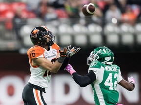 B.C. Lions' Bryan Burnham makes a reception as Saskatchewan Roughriders' Derrick Moncrief defends during the first half of a CFL football game in Vancouver, October 18.