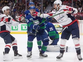 Washington Capitals' Tom Wilson, right, punches Vancouver Canucks' Tanner Pearson, centre, after the whistle during the first period  in Vancouver, on Friday October 25, 2019.