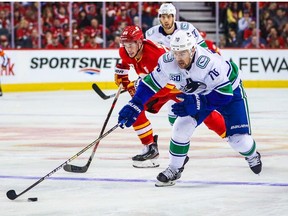 Canucks left wing Tanner Pearson reaches for the puck against the Calgary Flames during the first period in Calgary Oct. 5