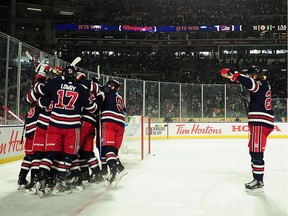 Winnipeg Jets forward Bryan Little (18) celebrates his goal against Calgary Flames goaltender David Rittich (33) (not pictured) during overtime of the 2019 Heritage Classic outdoor hockey game at Mosaic Stadium.