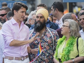 Prime Minister Justin Trudeau, left, attends the annual pride parade with NDP leader Jagmeet Singh and Green Party leader Elizabeth May in Montreal, Sunday, August 18, 2019.