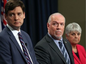 Premier John Horgan, centre, Finance Minister Carole James and Attorney General David Eby are looking around for others to blame for B.C.'s impending budget shortfall.