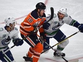 Edmonton Oilers forward James Neal gets chased down by Vancouver Canucks Christopher Tanev (8) and Guillaume Brisebois (56) during NHL pre-season action at Rogers Place on Sept. 19, 2019.