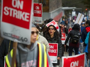 Strikers walk the picket line during a hotel workers strike at the Hyatt Regency in Vancouver on Oct. 6. A tentative deal has been reached at three of the hotels, the union said Tuesday.