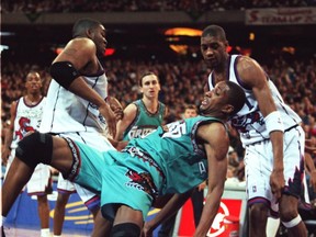 Vancouver Grizzlies star Shareef Abdur-Rahim lands awkwardly after colliding under the basket with Raptors' Oliver Miller, in this file photo.
