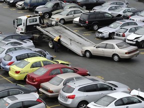 Workers at an ICBC damaged vehicle lot.