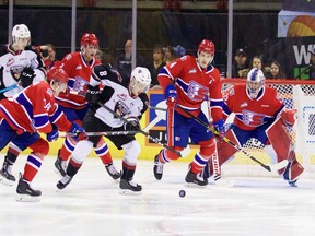 Tristen Nielsen battles for the puck with several Spokane Chiefs in the Vancouver Giants' 3-2 OT win Friday in Spokane.