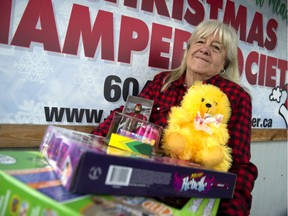 Lorraine Bates, chair of the Maple Ridge-Pitt Meadows Christmas Hamper Society, carries some donated presents at the organization's offices.