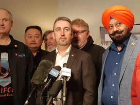 Unifor western regional director Gavin McGarrigle, flanked by his bargaining team, speaks to reporters before bargaining with Coast Mountain Bus Company.