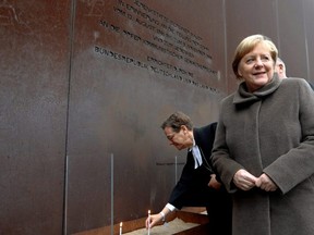 German Chancellor Angela Merkel attends lighting of candles at the memorial of the divided city and the victims of communist tyranny during a ceremony marking the 30th anniversary of the fall of the Berlin Wall at the Wall memorial on Bernauer Strasse in Berlin, Germany, Saturday, Nov. 9, 2019.