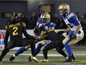 Winnipeg Blue Bombers wide receiver Nic Demski (10) runs the ball tackled by Hamilton Tiger-Cats quarterback David Watford (6) in the first half during the 107th Grey Cup championship football game at McMahon Stadium.