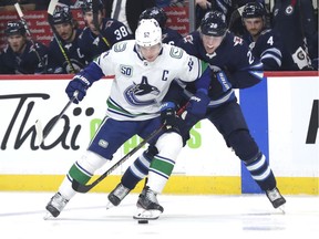Jets' winger Patrik Laine ties up Bo Horvat of the Vancouver Canucks during Friday's NHL action at Bell MTS Place in Winnipeg. The Canucks wrapped up a quick two-game road trip with a loss in the Manitoba capital.