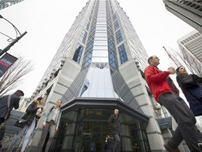 Pedestrians walk in front of an office tower in downtown Vancouver in this 2018 file photo.