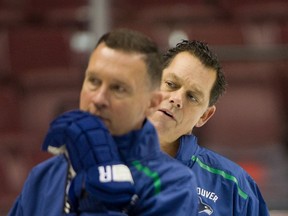 Vancouver Canucks Ian Clark (right) stands behind Assistant Coach Newell Brown (foreground-left) during practice at Rogers Arena in Vancouver, BC, Oct. 2, 2018.