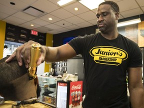 Junior Adusei, owner of Junior's Barbershop, with long time customer Isaiah Salomon.