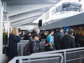Transit riders prepare to board a sea bus to North Vancouver from the Waterfront station terminal, Nov. 1.