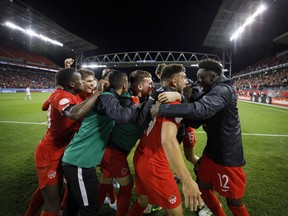 Alphonso Davies, right, celebrates with forward Lucas Cavallini and the rest of the Canadian squad after Cavallini scored during the second half of CONCACAF Nations League soccer action against the United States, in Toronto last month.