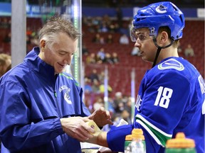 Vancouver Canucks athletic therapist Jon Sanderson tapes Canucks forward Jake Virtanen's left wrist before a game in the 2018-19 season.