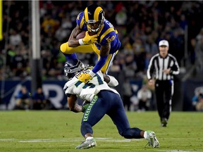 Wide receiver Josh Reynolds #83 of the Los Angeles Rams leaps over defensive back Quandre Diggs #37 of the Seattle Seahawks during the game at Los Angeles Memorial Coliseum on December 08, 2019 in Los Angeles, California.