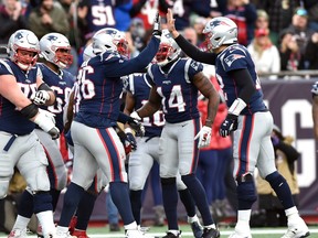 New England Patriots quarterback Tom Brady, right, high fives offensive tackle Isaiah Wynn, left, after a touchdown by running back James White (not pictured) during the second half at Gillette Stadium, in Foxborough, Mass., Dec. 29, 2019. (Bob DeChiara-USA TODAY Sports)