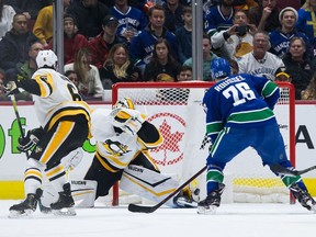 Pittsburgh Penguins goalie Matt Murray, centre, allows a goal to Vancouver Canucks' Jake Virtanen, not seen, as Canucks' Antoine Roussel and Penguins' John Marino, left, watch during first period NHL hockey action in Vancouver, Saturday, Dec. 21, 2019.