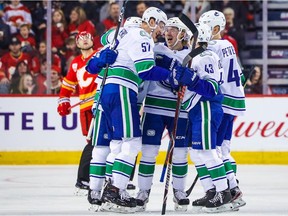 Vancouver Canucks defenceman Tyler Myers (57) celebrates his goal with teammates against the Calgary Flames during the first period at Scotiabank Saddledome.