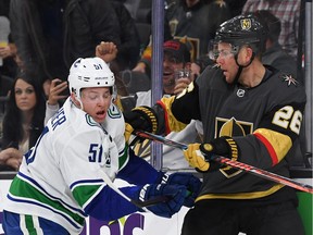 Troy Stecher, left, battles with Paul Stastny during a Pacific Division matchup.