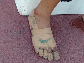 Rhea Bullos, 11, wears tape as makeshift running shoes during a 1,500-metre run at the Iloilo Sports Complex, in Iloilo, Philippines, Dec. 9, 2019.