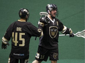 Vancouver Warriors' Keegan Bal, left, and Logan Schuss celebrate Schuss's goal against the New York Riptide in a regular-season NLL game at Rogers Arena in Vancouver on Dec. 14, 2019.