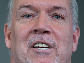 B.C. Premier John Horgan, pictured at the announcement of a new hospital for Surrey, must ponder whether to call a snap election or wait for the scheduled date as he heads into the new year.